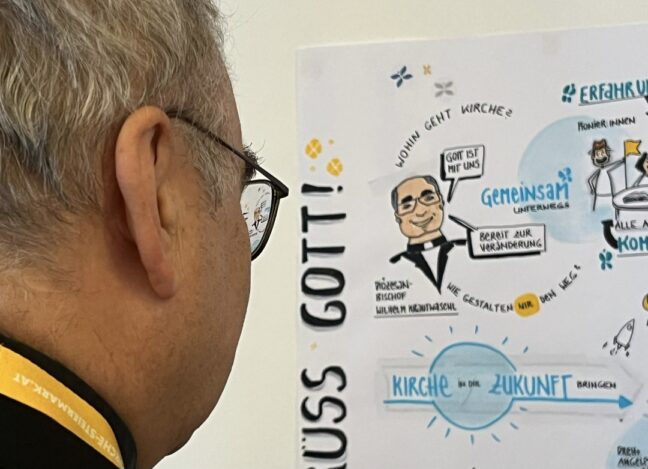 Diözesanbischof Wilhelm Krautwaschl betrachtet das Graphic Recording